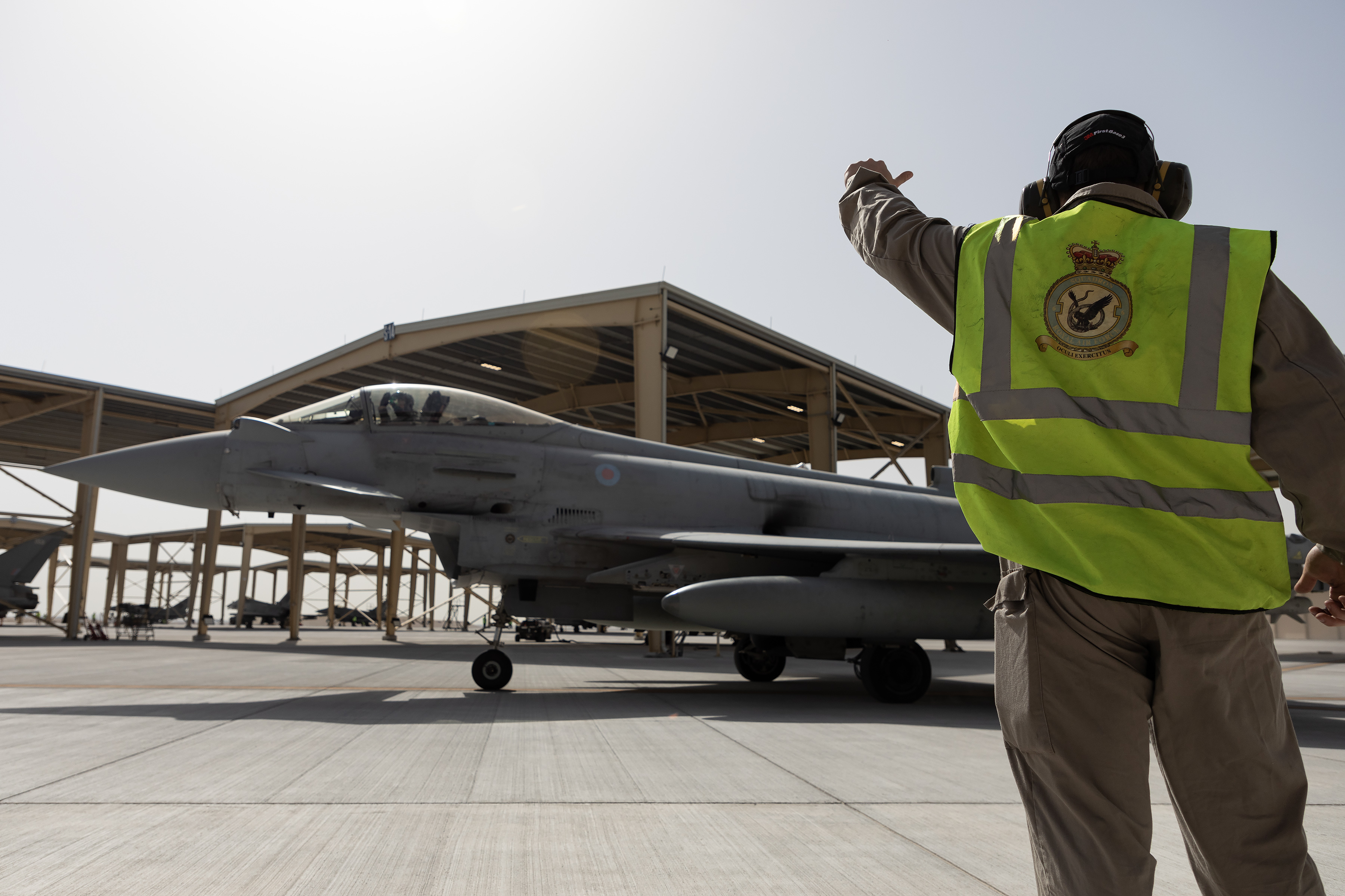 Image shows RAF Aviator guiding a Typhoon on the airfield.